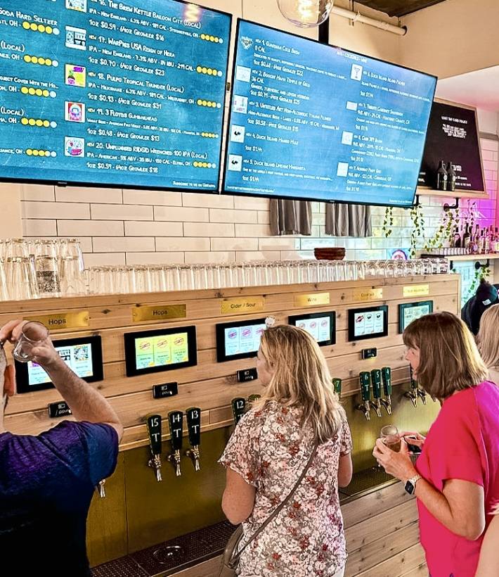 Guests pour their own beer at the tap wall at Tapster Cleveland.